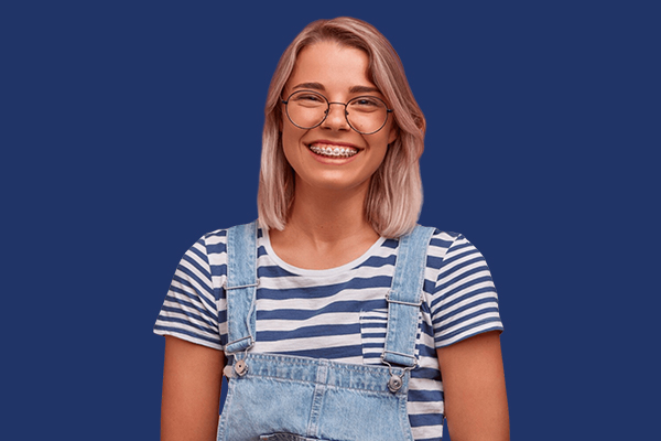 A smiling woman wearing traditional braces on a blue background.