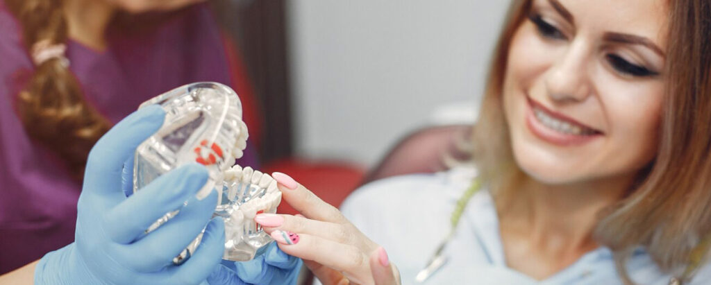 A woman is holding a dental model in her hands.