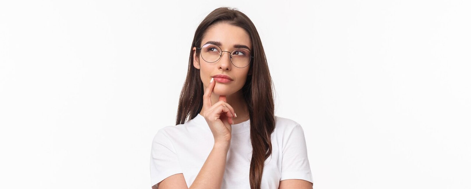 A young woman wearing glasses is thinking about the symptoms of underbite teeth